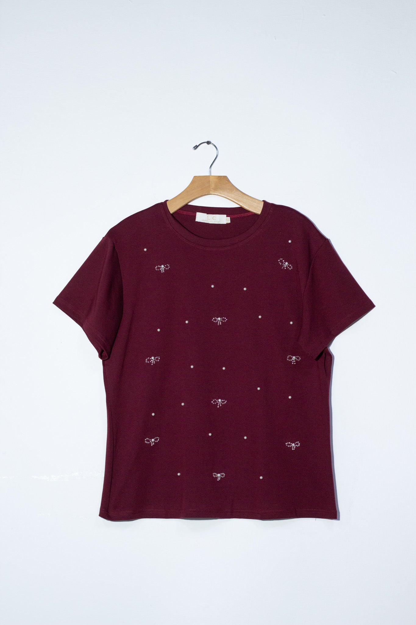 Blusa detalles moños y perlas