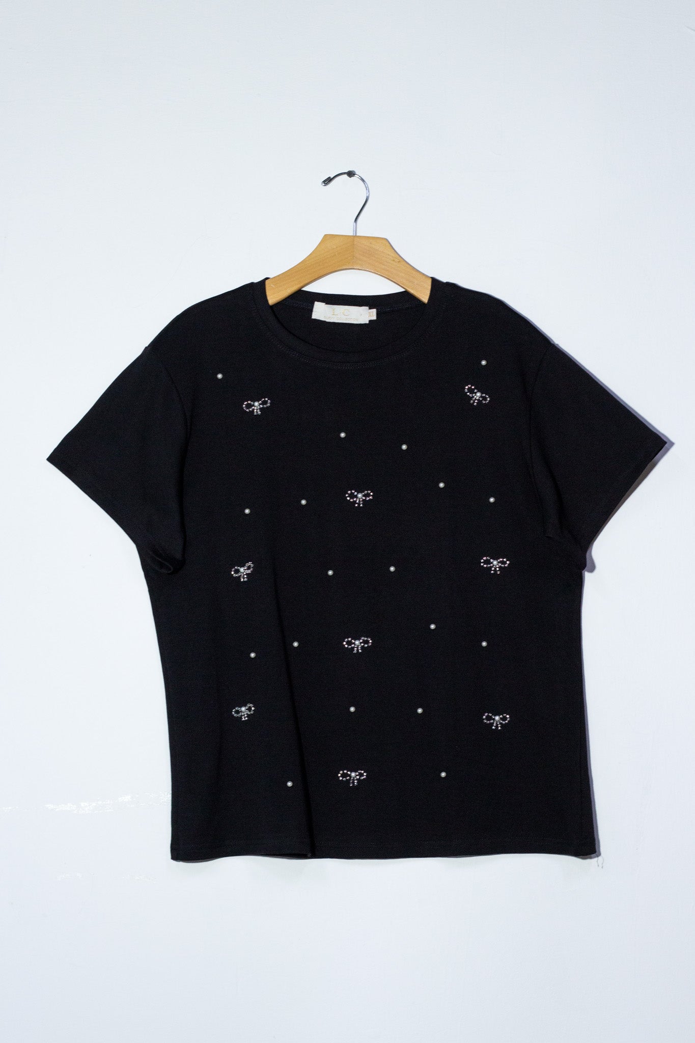 Blusa detalles moños y perlas